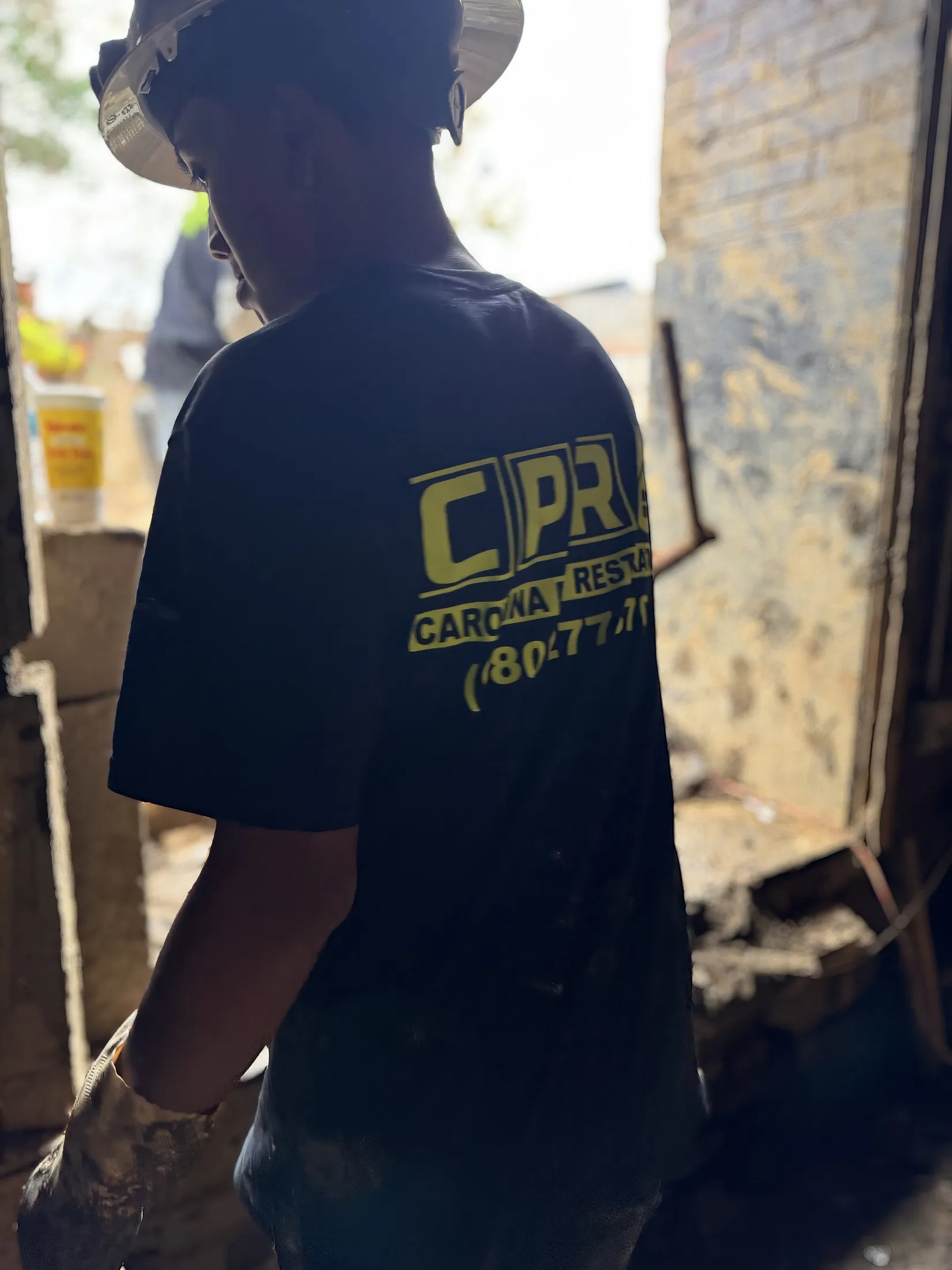 A Carolina Pro Restoration crew member in a hard hat on a storm-damage job site