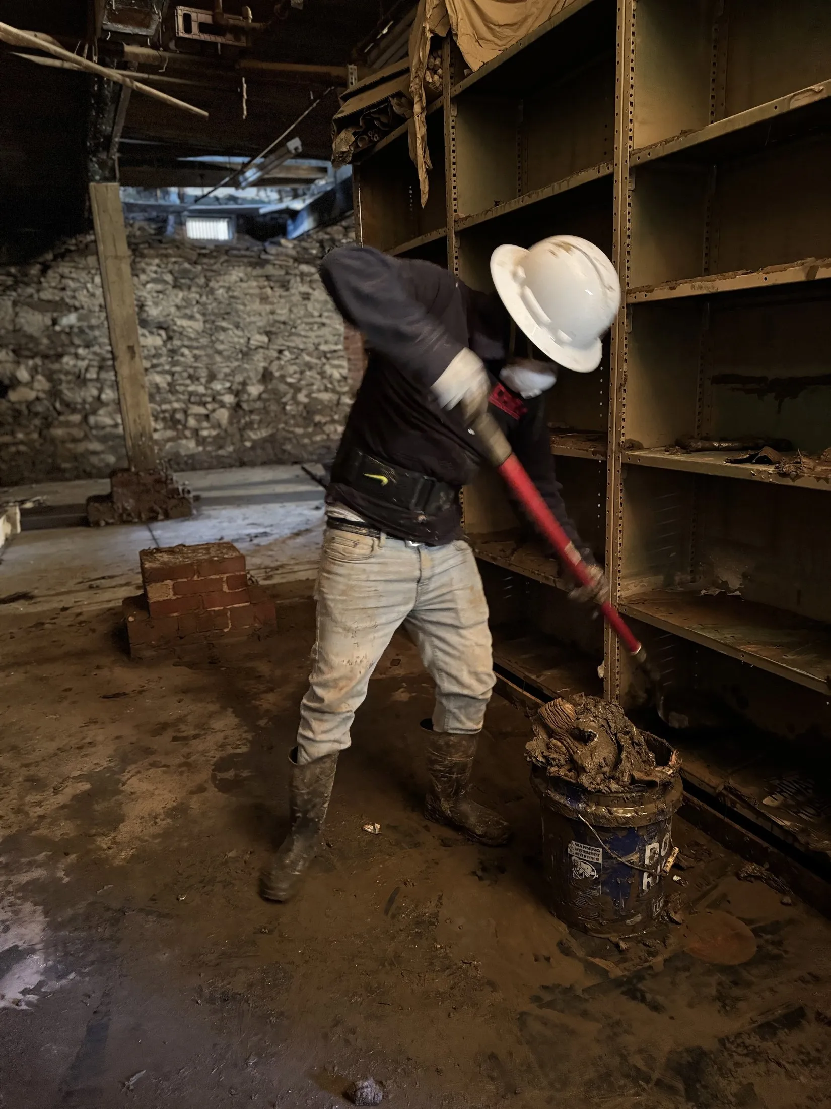 Technician removing contaminated water and debris in protective gear