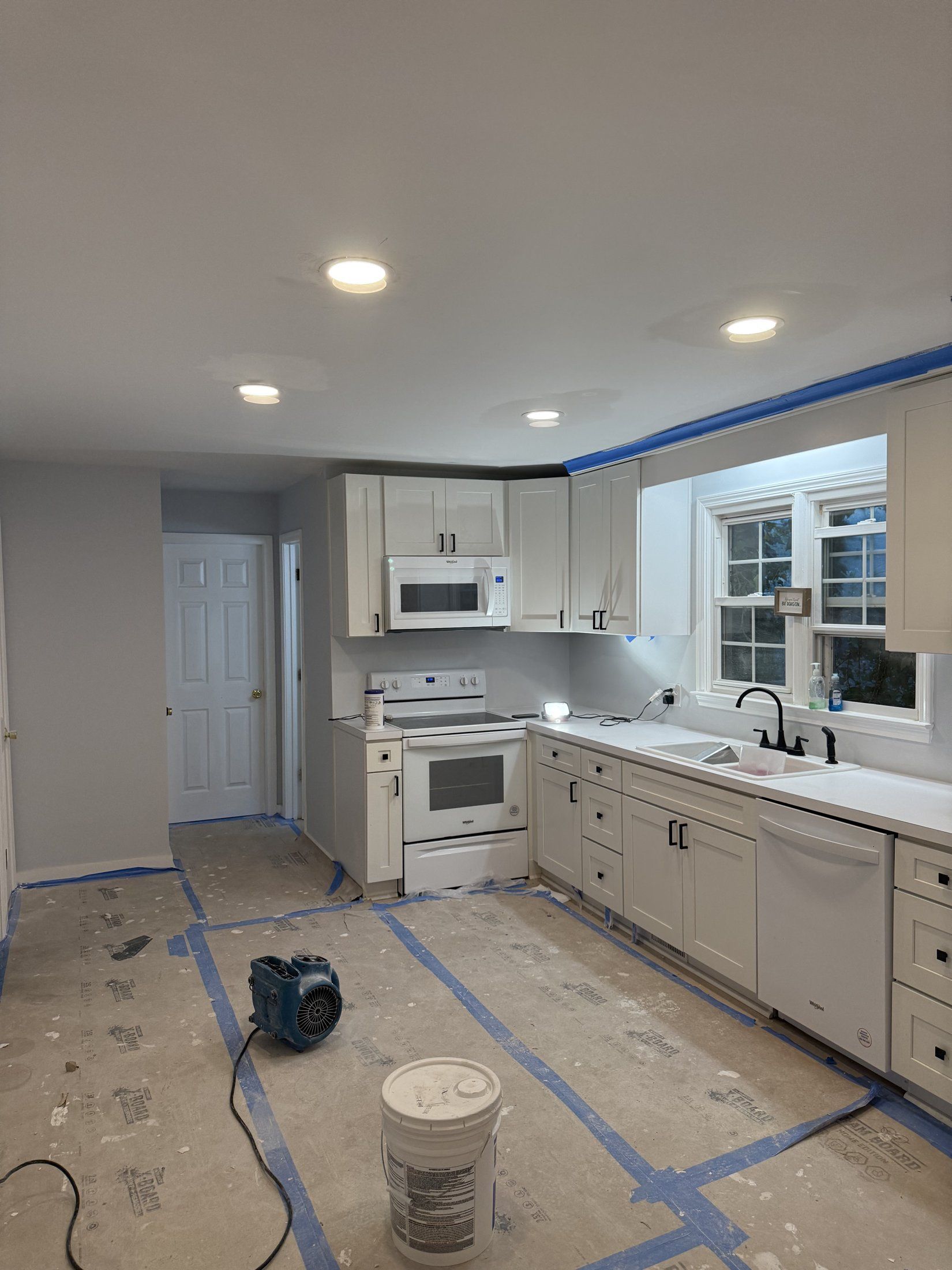 The same kitchen rebuilt with new cabinets, counters, and flooring