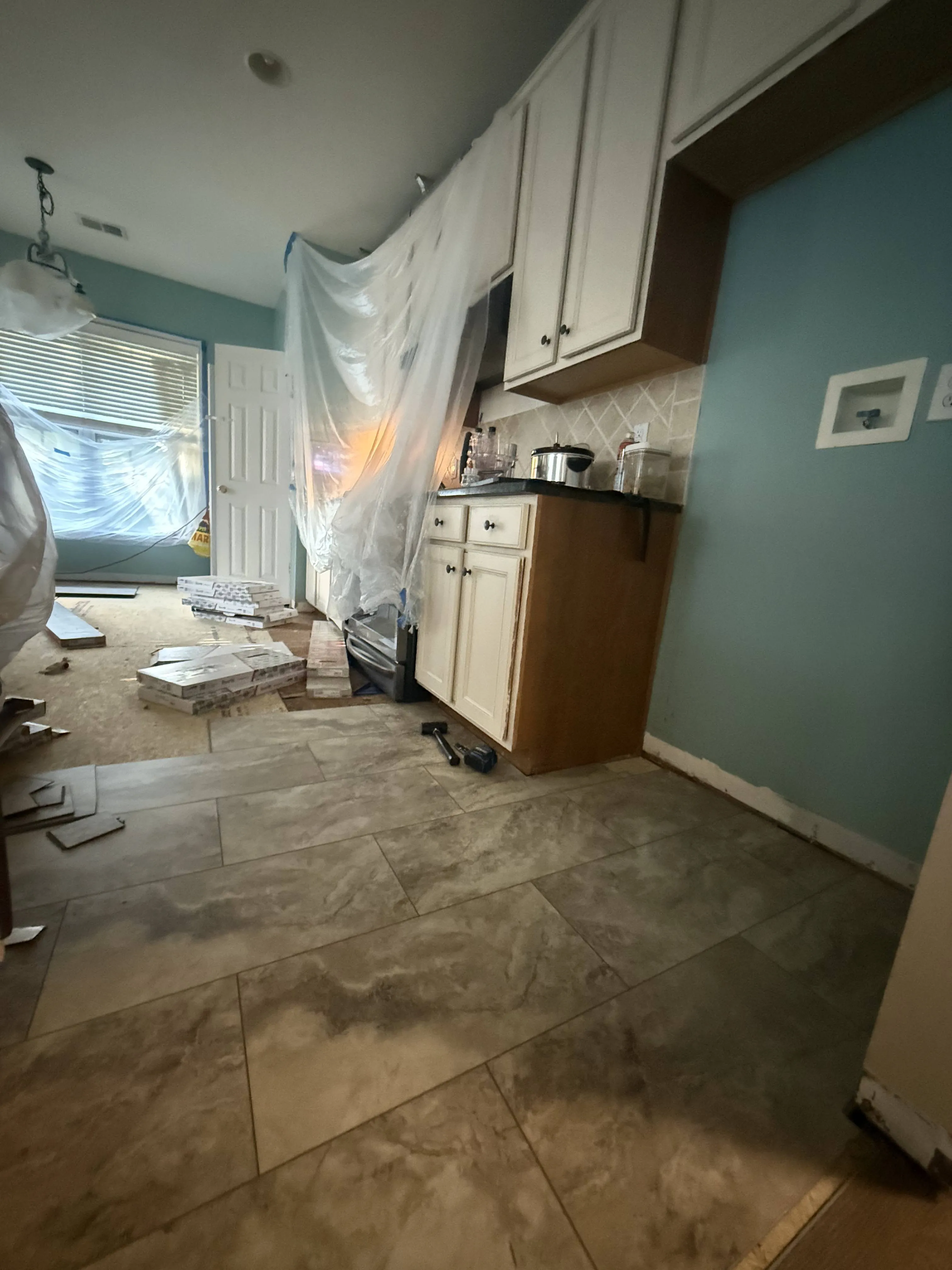 A kitchen with newly installed tile flooring during a Carolina Pro Restoration rebuild